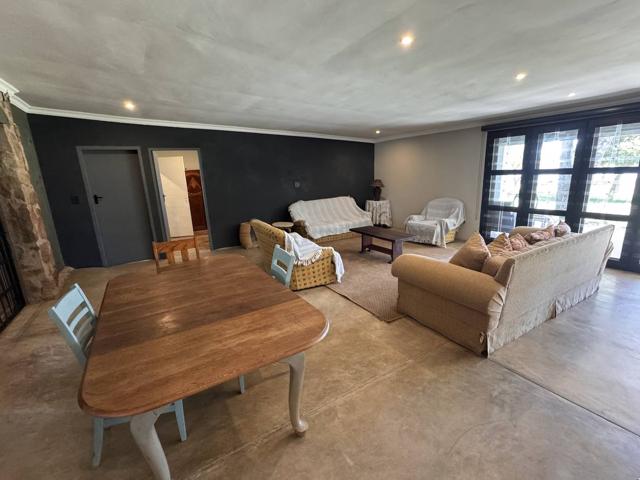 Open-plan lounge and dining area with wooden table and sofas
