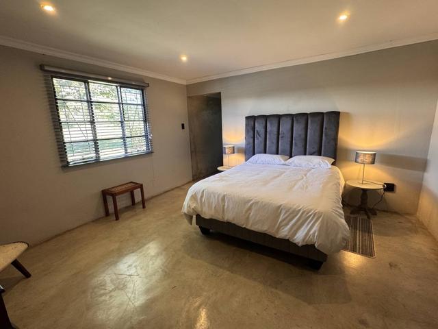 Master bedroom with queen bed and tall upholstered headboard