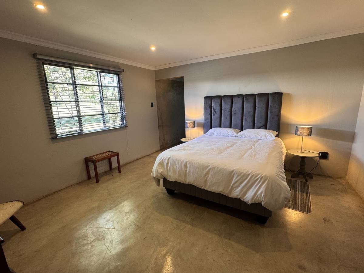 Master bedroom with queen bed and tall upholstered headboard